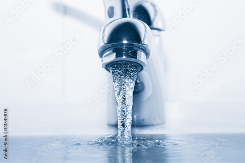 Plakat Faucet z płynącej wody zbliżeniem