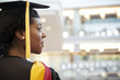 © Cavan Images - Woman in graduation gown looking away