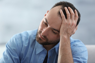 Wall Mural - Portrait of handsome depressed man at home