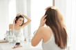 © Africa Studio - Young woman with hair loss problem in front of mirror at home