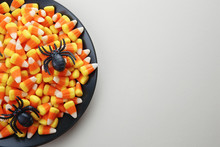 Plate With Tasty Halloween Candies On Color Background