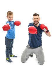 Father and son with boxing gloves on white background