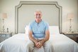 © WavebreakMediaMicro - Portrait of smiling senior man sitting on bed in bedroom