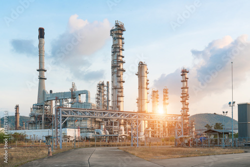 Plakat Przemysłowy widok przy rafinerii ropy naftowej rośliny formy przemysłu strefą z wschodem słońca i chmurnym niebem