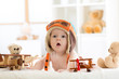 © Oksana Kuzmina - Funny baby boy weared pilot hat with wooden airplane and teddy bear toys