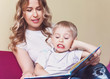 © kolyadzinskaya - happy baby boy learning to read, Mama reads fairy tales to his son