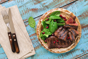 Poster - Plate with grilled steak, spinach leaves and pomegranate