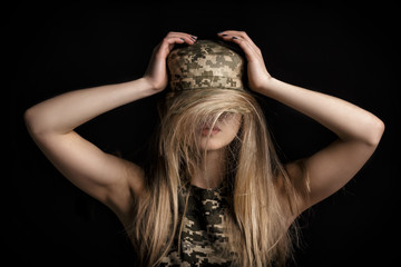 portrait of beautiful woman soldiers in military attire on black background