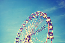 Vintage Stylized Picture Of A Ferris Wheel Against The Blue Sky.