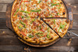 © revalent - Delicious pizza with mushrooms - thin pastry crust isolated at wooden background on wooden desk