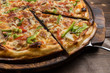 Delicious pizza with mushrooms - thin pastry crust isolated at wooden background on wooden desk