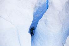 Low Angle View Of Man Climbing Snow Covered Mountain