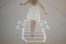 Low Section Of Girl Playing Hopscotch On Footpath