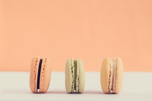 Raw Of Pastel Colors Assorted French  Macaroons On A Colored Background.  Copy Space For Text. Horizontal