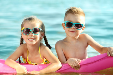 Wall Mural - Cute kids swimming on inflatable mattress