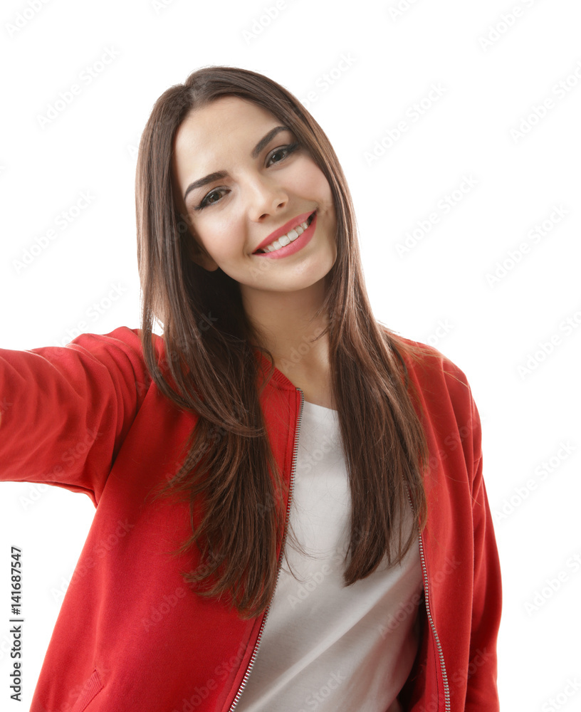 Beautiful young woman taking selfie on white background