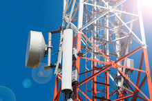 Mobile Phone Communication Antenna Tower With Satellite Dish On Blue Sky Background