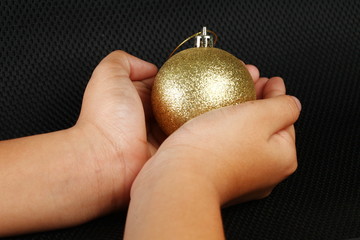 The woman hand holding action of the christmas decoration ball in her hand  represent the christmas theme concept related idea.