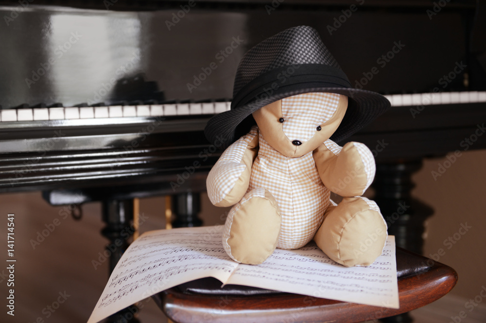 Teddy bear sitting on chair on piano background