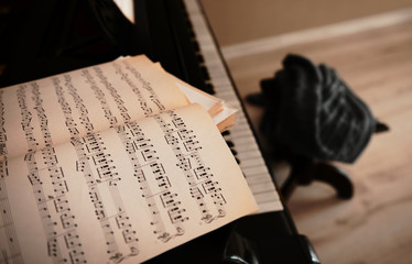 Wall Mural - Music notes on black piano, close up