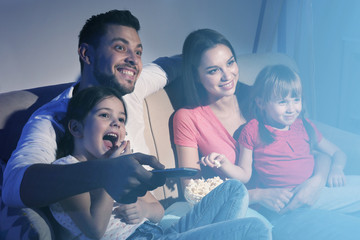 Wall Mural - Happy family watching TV on sofa at home