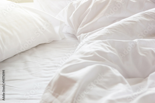 Fotografía wrinkle messy blanket and white pillow in bedroom after waking up in the morning, from sleeping in a long night, details of duvet and blanket, an unmade bed in hotel bedroom with white blanket