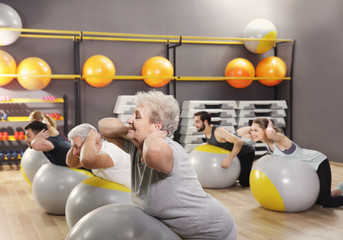 Canvas Print - People of different ages training with fit balls in gym