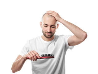 Hair loss concept. Young man with hair comb on white background