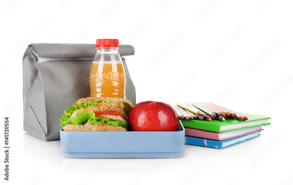 Lunch box and bag with food and stationery on white background