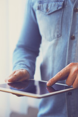 Wall Mural - man holding white digital tablet, view close up. toned