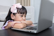 Leinwandbild Motiv Fatigued Asian Chinese little girl looking at computer screen
