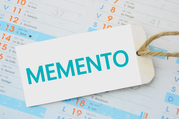 MEMENTO,sur écriteau sur fond calendrier 