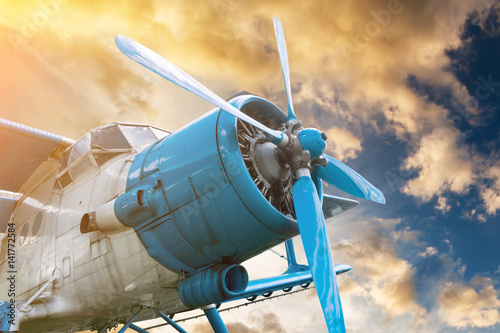 Fotomural Avión con hélice en hermoso cielo brillante puesta de sol de fondo