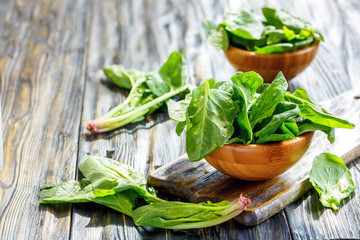 Wall Mural - Wooden bowls with spinach leaves.