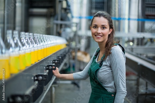 Fotomural Female factory worker standing near production line