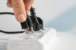 © toa555 - Close up Elderly hand plugging into electrical outlet