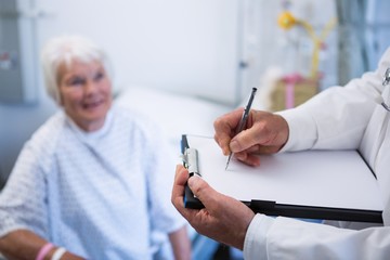 Canvas Print - Doctor discussing medical report with senior patient