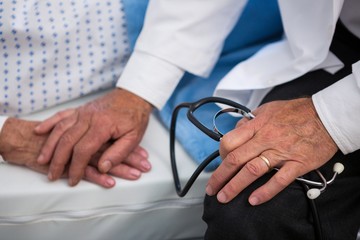 Canvas Print - Mid-section of doctor consoling senior patient