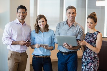 Wall Mural - Smiling business colleagues using mobile phone