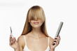 © sanneberg - Beautiful blond haired woman holding comb and scissors