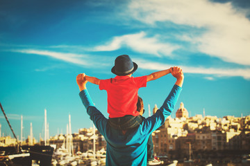 family travel - father and son on shoulders play at sky