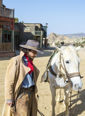Fototapete - Cowboy with his horse at the Western Town at Mini Hollywood, Tabernas, Almeria Province, Andalusia, Spain