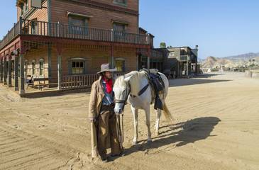 Fototapete - Cowboy with his horse at the Western Town at Mini Hollywood, Tabernas, Almeria Province, Andalusia, Spain