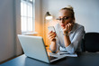 © bnenin - Overworked and tired businesswoman at work in her office using smartphone