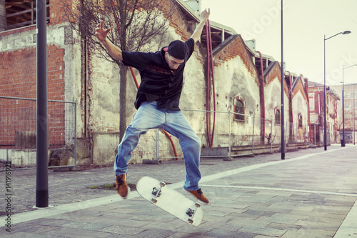 young boy jumping with skateboard in outskirt street - Buy this ...