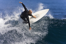 A Surfer Carves A Turn At The Tip Of The Wave.