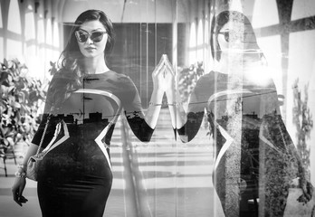 Monochrome double exposure of elegant woman with reflection and city skyline