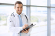 © volha_r - Doctor man fills up medical history form