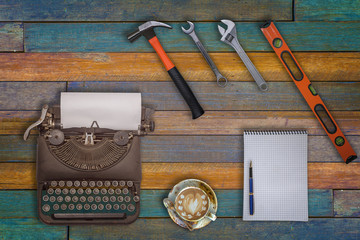 Top view typewriter ,a cup of coffee and engineer equipment on wooden background