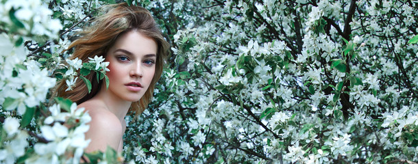 Wall Mural - beautiful young girl lies on a clearing among white flowers. white flowers. chamomile. a girl with h